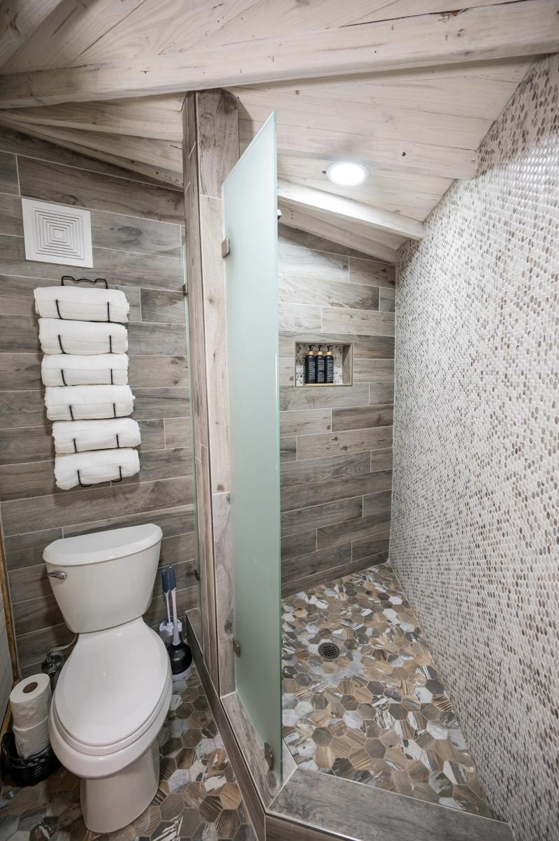 Blue Jay Yurt — private tiled bathroom with walk-in shower and fresh towels.