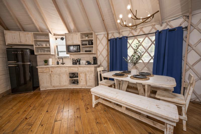 Blue Jay Yurt — full kitchen and dining nook beneath the canvas ceiling.