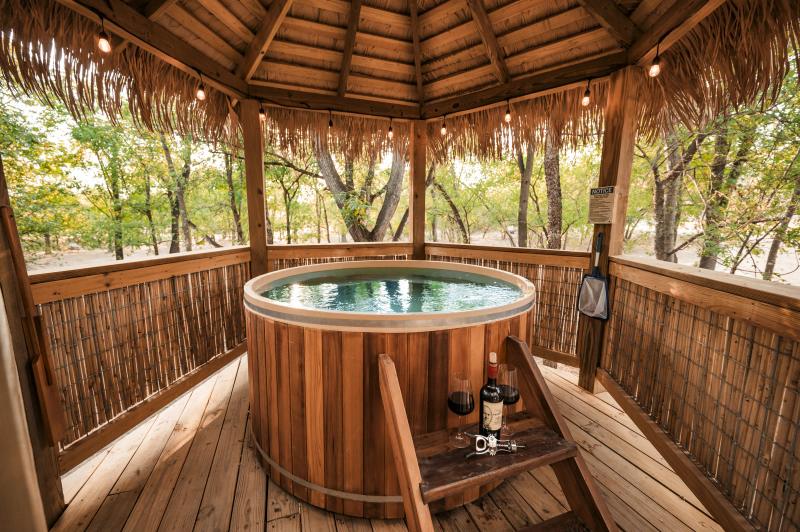 Blue Jay Yurt — round cedar hot tub inside the private thatched gazebo.