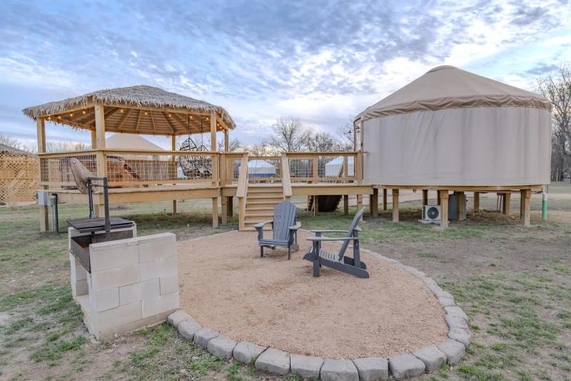 Canary Yurt — yurt, gazebo, fire pit, and Adirondack chairs beneath a blue evening sky.