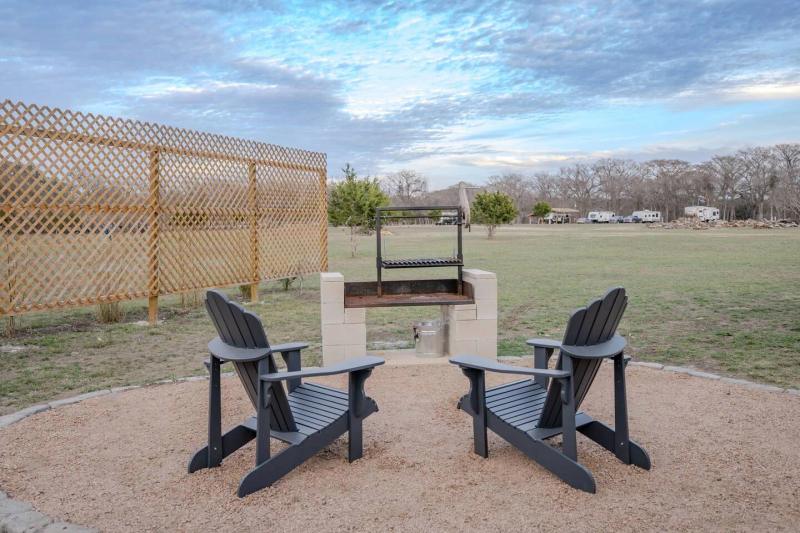 Canary Yurt — two Adirondack chairs facing the private masonry fire pit.