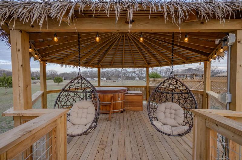 Canary Yurt — pair of cushioned hanging chairs inside the private gazebo.
