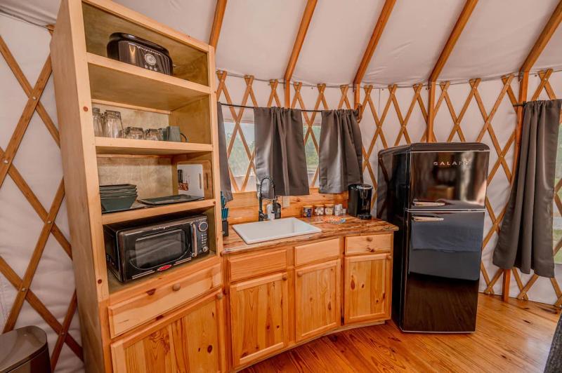 Cockatoo Yurt — kitchenette with wood cabinetry, refrigerator, microwave, and coffee maker.