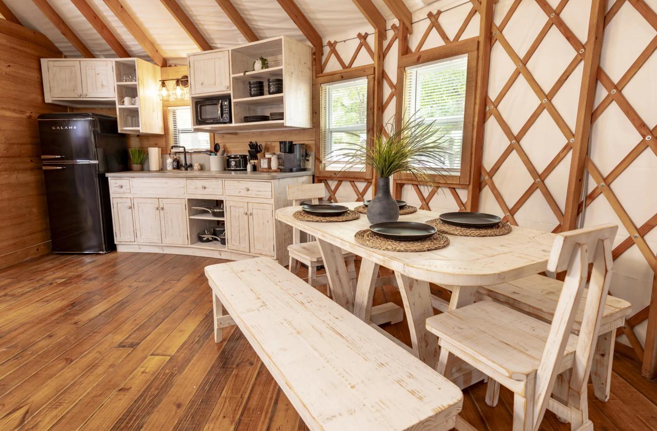 Hoot Owl Yurt — whitewashed kitchen and farm table set for four beside the lattice windows.