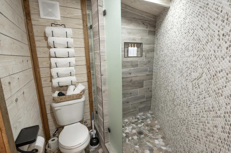 Hoot Owl Yurt — private tiled bathroom with walk-in shower and fresh towels.
