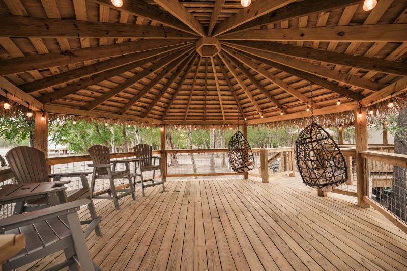 Hoot Owl Yurt — spacious private gazebo with a hanging chair and dining table.