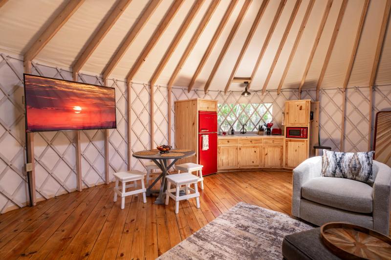Love Bird Yurt — red retro refrigerator, bistro table for two and wall-mounted television.