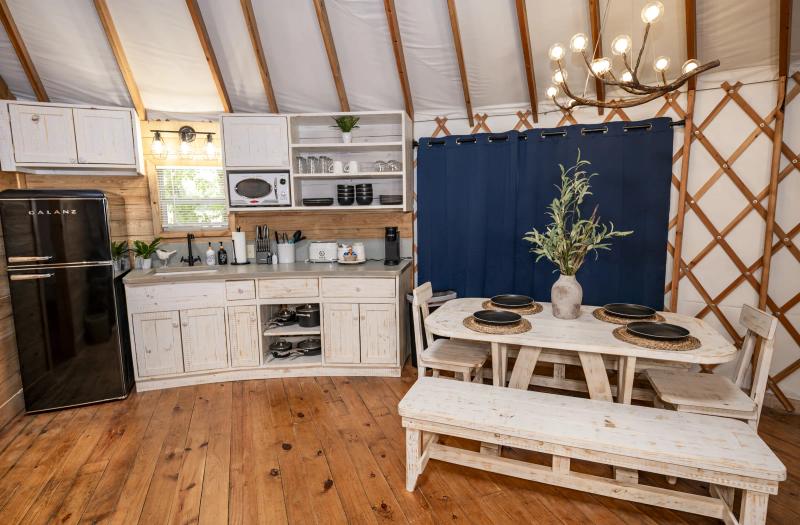 Mourning Dove Yurt — full kitchen and dining nook beneath the circular canvas roof.