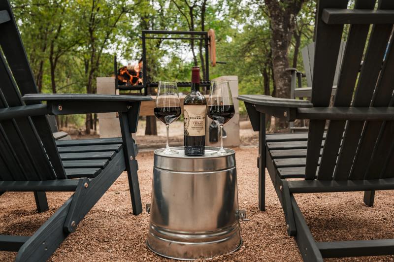 Mourning Dove Yurt — wine and glasses between Adirondack chairs at the private fire pit.