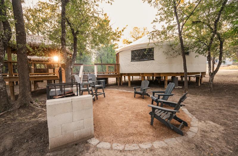 Mourning Dove Yurt — private fire-pit seating area shaded by live oaks.