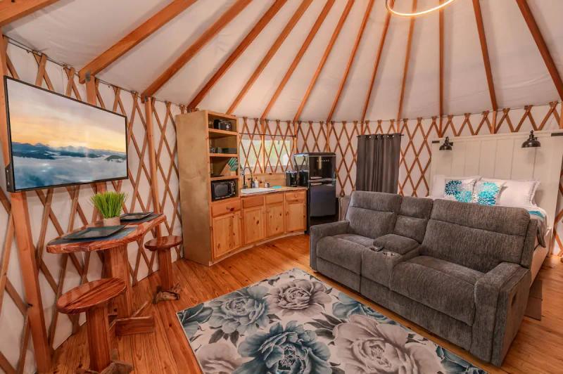 Peacock Yurt — living room with sofa, television, and colorful peacock accents.