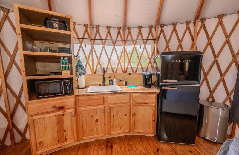 Peacock Yurt — wood kitchenette with refrigerator, microwave, and coffee station.