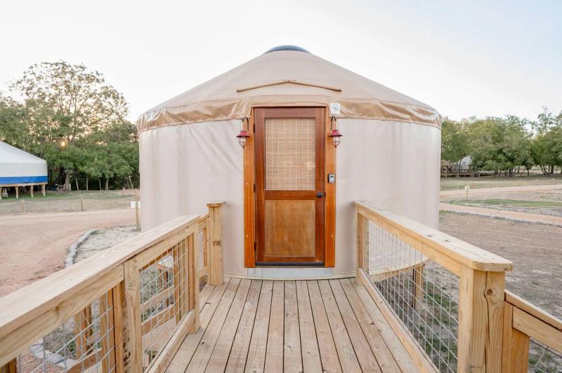 Peacock Yurt — wooden entry ramp leading to the yurt's double doors.