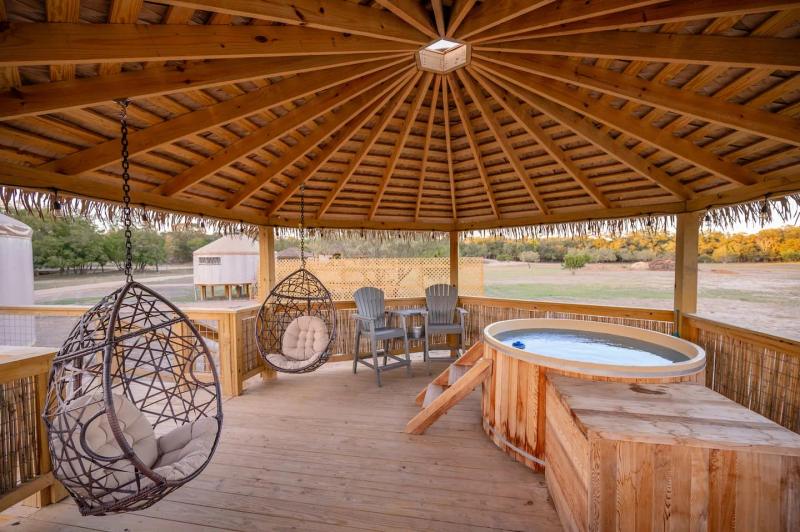 Peacock Yurt — cedar hot tub and lounge seating inside the private gazebo.
