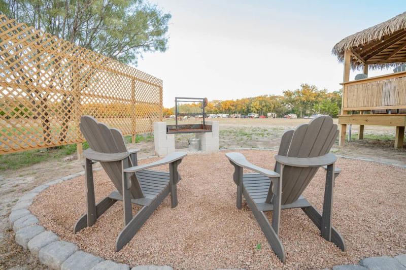 Peacock Yurt — Adirondack chairs beside the private masonry fire pit.