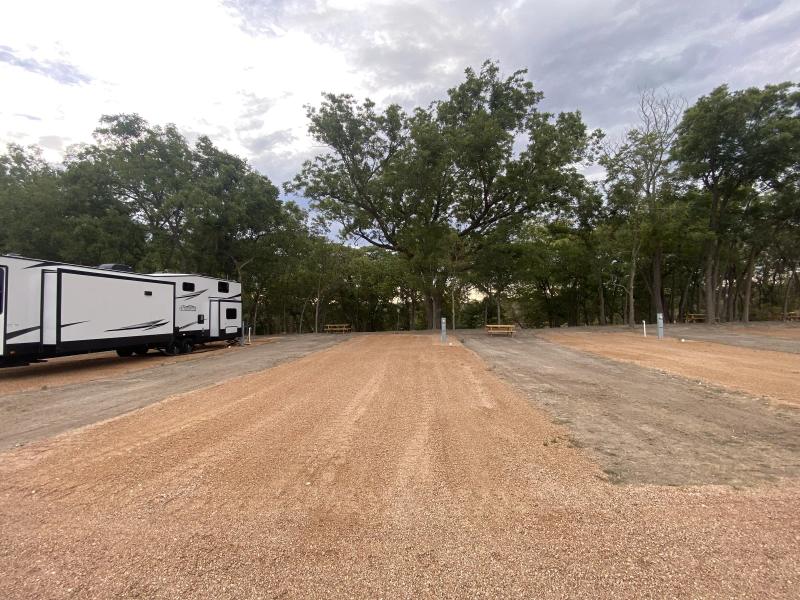 River Yurt Village RV Park — travel trailer levelled on one of the oversized gravel pads with open room to spare behind it.
