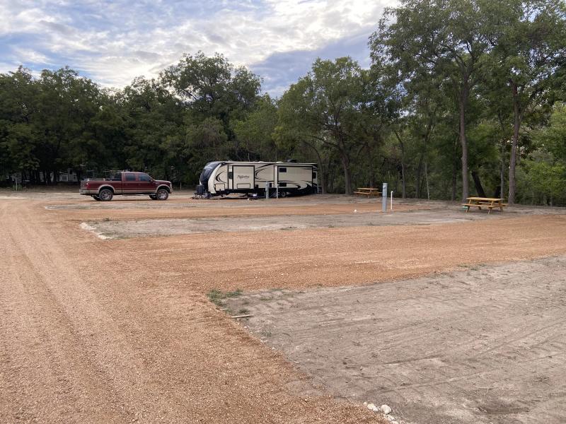 River Yurt Village RV Park — pickup truck and fifth-wheel set up on neighboring sites with space between the rigs.