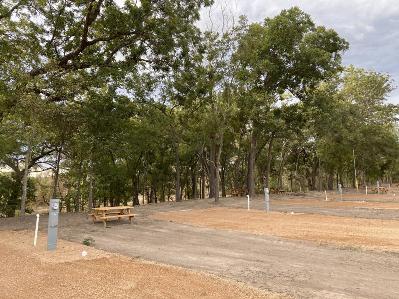 River Yurt Village RV Park — oversized site with its own picnic table and a utility pedestal at the pad's edge.