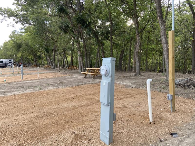 River Yurt Village RV Park — close view of a site's hookup pedestal with 30 and 50 amp outlets, water spigot and sewer connection.